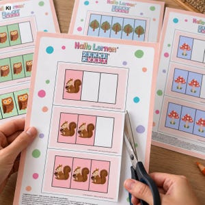 May include: A printable educational worksheet titled Hallo Lernen Zehnerwelt featuring rows of boxes with illustrations of squirrels holding acorns, trees, and mushrooms. The page is decorated with colourful polka dots and is being cut with scissors.