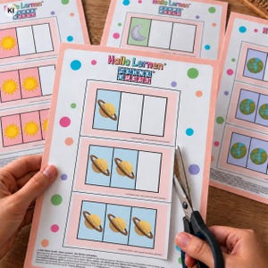 Pode incluir: Uma folha de exercícios educativa impressa intitulada Hallo Lernen Zehnerwelt, apresentando linhas de caixas com ilustrações de planetas. A folha tem uma borda rosa claro e bolinhas coloridas. Uma tesoura está posicionada para recortar.
