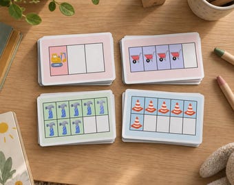 May include: Four stacks of rectangular educational flashcards featuring construction-themed graphics. The cards display grids with illustrations of yellow excavators, red wheelbarrows, blue hammers, and orange traffic cones on pastel backgrounds.