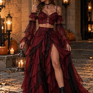May include: A two-piece outfit consisting of a dark red cropped corset top with lace-up detailing and off-the-shoulder ruffled sleeves, paired with a matching floor-length layered skirt featuring a high side slit and black trim accents.