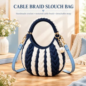 May include: A crochet slouch bag featuring a navy blue and white cable braid pattern. The bag includes a rounded handle, a detachable light blue strap, and a gold-toned chain accent with a white pearl charm. Text reads CABLE BRAID SLOUCH BAG.