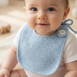 Häkelanleitung für ein Baby-Lätzchen mit überkreuzten Bändern und Knopfverschluss (PDF-Download)