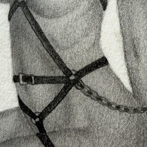 May include: A charcoal pencil drawing depicting a body harness constructed from thin black straps, metal rings, and buckles. The harness features an integrated metal chain segment extending from the waist area, rendered in a realistic graphite style.