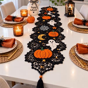 Peut inclure: Un chemin de table en crochet noir orné de citrouilles orange, de fantômes blancs, de croissants de lune jaunes, de toiles d'araignée blanches et de petites étoiles jaunes. Il présente un bord festonné et une pampille noire sur perle.