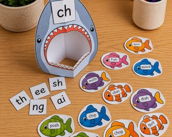 Könnte beinhalten: Ein Haifisch-Ausschnitt aus Papier mit offenem Maul und den Buchstaben ch, umgeben von verschiedenen bunten Fischen mit Wörtern wie fish, moth, chin, dish, chip, chop, path, quiz, quack, quit sowie Buchstabenkärtchen mit th, ee, sh, ng und ai.