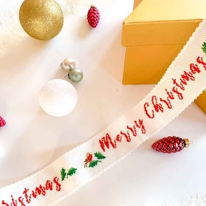 Patrón de punto de cruz de cinta navideña con letras manuscritas de Feliz Navidad, pájaro y hojas. Patrón de punto de cruz digital