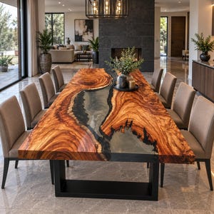 Puede incluir: Una mesa de comedor rectangular con un tablero de madera de borde natural y un río central de resina gris translúcida, apoyada sobre una base de metal negro en forma de U, rodeada por ocho sillas tapizadas en tela de color beige.