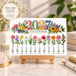 May include: A 15.24cm x 10.16cm mini desk calendar for 2027 featuring colourful floral illustrations. The design includes the year 2027 in large numbers surrounded by flowers, with twelve individual monthly flowers labelled from January to December.