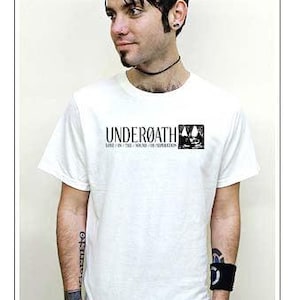 Puede incluir: Una camiseta blanca de manga corta con el texto negro "UNDERØATH" y "LOST IN THE SOUND OF SEPARATION" impreso en el pecho, acompañado de un pequeño cuadrado negro que contiene una ilustración estilizada de dos figuras.
