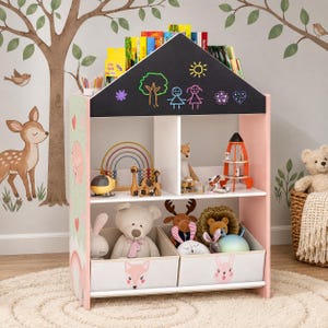 May include: A house-shaped wooden toy storage unit with a black chalkboard roof featuring colorful chalk drawings. The unit has two shelves, two fabric storage bins with animal faces, and a light pink frame with green side panels.