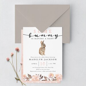 May include: A baby shower invitation with a pink and white floral design. The invitation features a watercolor illustration of a brown bunny and the text "Some bunny is having a baby!"  The invitation is for Madelyn Jackson and is scheduled for April 10th at 1:00 PM. The address is 100 Cottontail Lane, City, State Zip. RSVP to 000.000.0000. Registered at Crate & Kids and Land of Nod.