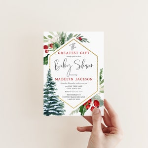 Peut inclure: Une invitation de f&ecirc;te pr&eacute;natale blanche avec un cadre hexagonal dor&eacute; et une illustration aquarelle d'un pin enneig&eacute; et de baies rouges. Le texte indique "The Greatest Gift" et "Baby Shower" en l'honneur de "Madelyn Jackson".