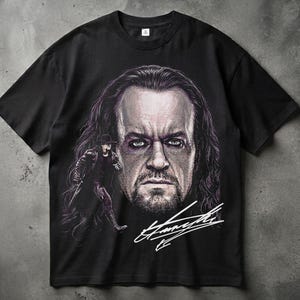 Puede incluir: Una camiseta negra de manga corta con un gran estampado gráfico de un hombre con pelo largo y oscuro y mirada intensa. A la izquierda, una figura más pequeña con sombrero y abrigo negros. Una firma blanca está impresa en la esquina inferior.