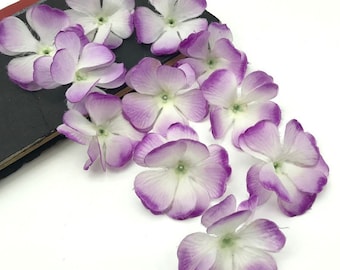 May include: A cluster of white and purple paper flowers with a white center. The flowers are arranged in a cascading pattern, with the largest flower at the top and the smallest flower at the bottom.