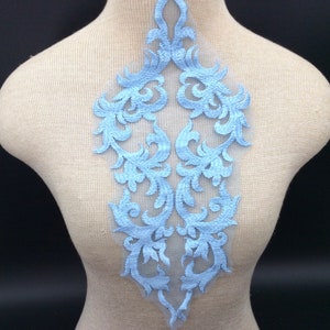 Op de afbeelding: Lichtblauwe kant applique met een delicaat bloemenmotief. De applique is perfect om een ​​toets van elegantie toe te voegen aan elk kledingstuk of project.