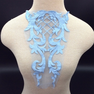 Op de afbeelding: Lichtblauwe kant applique met een delicaat bloemenpatroon. De applique is perfect om een ​​toets van elegantie toe te voegen aan elk kledingstuk.