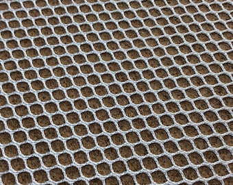 Peut inclure: Filet en maille blanche avec un motif en losange. Le filet est posé à plat sur une surface brune.