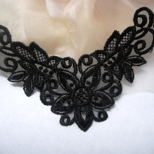 May include: Black lace trim with a floral design. The lace is delicate and intricate, with a scalloped edge.