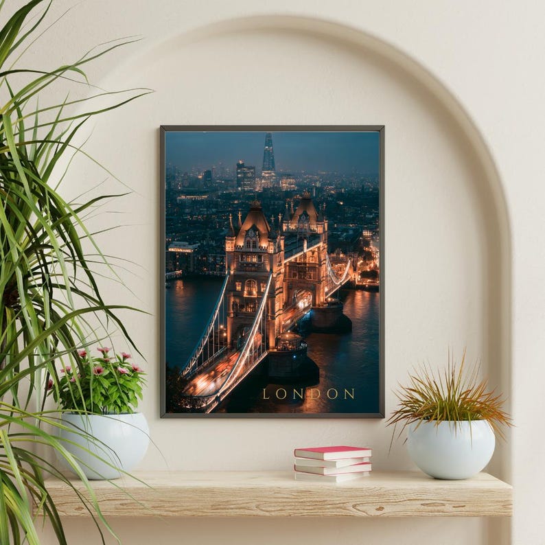 May include: A rectangular wall art print featuring a night view of Tower Bridge in London, illuminated with warm golden lights against a dark blue twilight sky. The word LONDON is printed in gold capital letters at the bottom of the image.