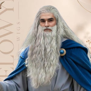 May include: A long, wavy, silver-grey wig and matching full beard set. The hair features a center part and textured, flowing strands. The set is displayed on a person wearing a grey tunic, a blue cloak with a circular gold and blue brooch, and a wide, ornate, metallic-toned belt.