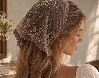 May include: A triangular headscarf in a muted taupe shade, featuring intricate silver and gold sequin embroidery in swirling patterns. The edges are finished with a delicate, matching crochet lace trim, providing a textured and detailed appearance.