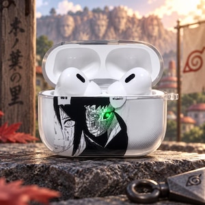 May include: A clear protective case for wireless earbuds featuring a black and white manga-style graphic of a character with a glowing green eye. The case is open, revealing two white earbuds inside, and includes a small side loop for a keychain attachment.