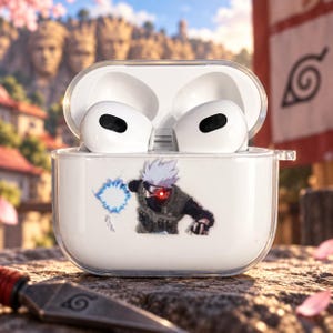 May include: A clear protective case for wireless earbuds featuring a graphic of a spiky-haired character with a red eye and a blue energy orb. The case is open, revealing white earbuds inside, and is constructed from a transparent material.