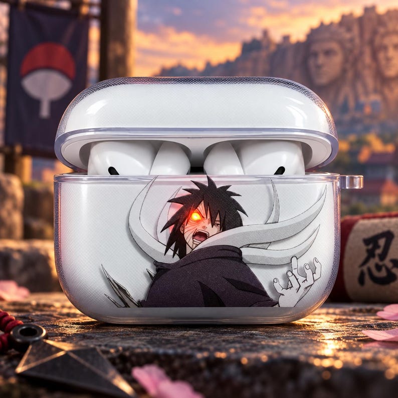May include: A clear plastic protective case for wireless earbuds featuring a graphic print of a dark-haired character with a glowing red eye and white swirling patterns. The case is open, revealing white earbuds inside the charging compartment.