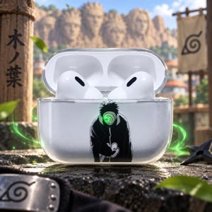 May include: A clear protective case for wireless earbuds featuring a graphic of a masked character in a black cloak with a swirling green eye design. The case is open, revealing white earbuds inside, and the exterior has a subtle textured finish.