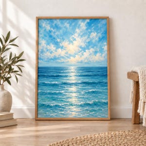 May include: A vertical rectangular framed painting depicting a seascape with a bright blue ocean and gentle waves under a sky filled with soft white clouds. The sunlight reflects off the water surface, creating a shimmering path toward the horizon.