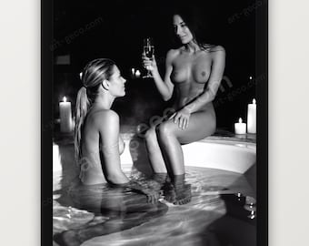 Könnte beinhalten: Ein schwarz-weiß gerahmtes Foto, das zwei Personen in einer Badewanne zeigt. Eine Person sitzt im Wasser, während die andere auf dem Wannenrand sitzt und ein Glas Champagner hält. Mehrere brennende Kerzen sind um die Wanne herum platziert.