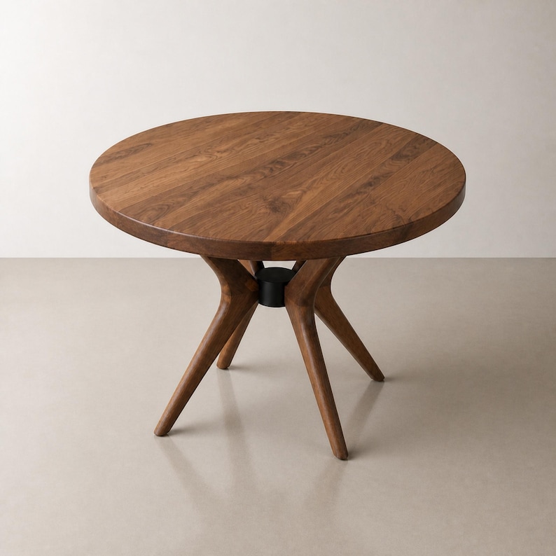 Elevated studio view showing the circular walnut top, panel grain and radial wood base