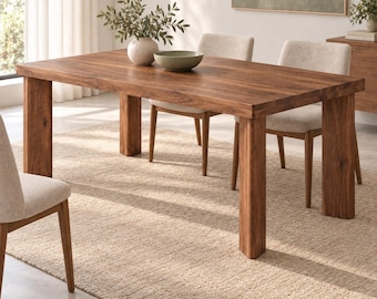 May include: A rectangular wooden dining table with a natural brown grain finish and four thick, straight legs. The table is accompanied by four upholstered chairs with light beige fabric seats and wooden legs, arranged around the table.