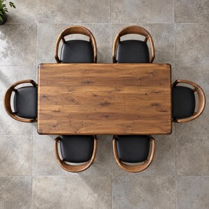 Top-down view of the walnut tabletop with six surrounding chairs on a ceramic floor. Styled with walnut chairs and black seats. This listing includes the dining table only; chairs and decorative accessories are not included.