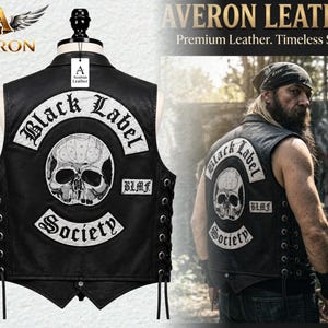 Puede incluir: Un chaleco de cuero negro con parches bordados en blanco que incluyen el texto Black Label Society y un gráfico de calavera. El chaleco tiene cordones laterales negros y una pequeña etiqueta con las siglas BLMF. Incluye el logo Averon Leather.
