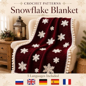 Puede incluir: Una manta de ganchillo de color rojo oscuro con motivos de copos de nieve blancos y un borde de pompones blancos. El texto CROCHET PATTERNS Snowflake Blanket y 5 Languages Included es visible. La manta está sobre una silla.