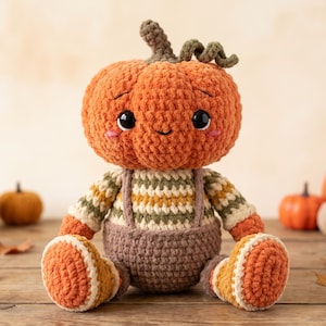 May include: A crocheted plush toy shaped like a pumpkin with a round orange head, a green stem, and large black eyes. The figure wears a striped sweater in cream, green, and yellow, paired with brown overalls and orange and cream patterned boots.