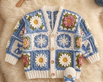 May include: A long-sleeve crochet cardigan featuring a patchwork of blue, white, pink, and green floral and snowflake motifs with four wooden buttons down the front, accompanied by a single matching white crochet shoe with a blue ribbon bow.
