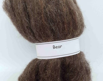May include: A bundle of brown wool roving labeled "Bear".
