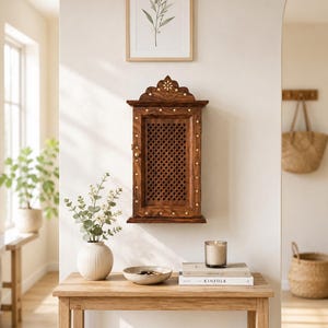 May include: A rectangular wall-mounted wooden cabinet with a dark brown finish and a lattice-patterned door. The cabinet features a decorative arched top with inlaid floral details and small diamond-shaped accents along the frame.