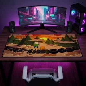 Può includere: Un tappetino da scrivania rettangolare con un'illustrazione stampata di due personaggi dei cartoni animati in piedi su un ponte di legno al tramonto. La scena include montagne verdi, un sole giallo brillante e un cielo nuvoloso. Bordo nero.