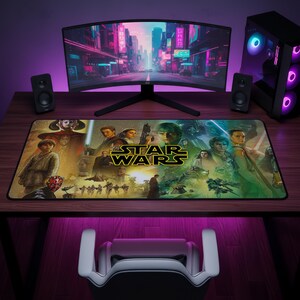 May include: A rectangular desk mat featuring a Star Wars collage with various characters, ships, and the yellow Star Wars logo centred. The mat displays a vibrant, multi-coloured scene with figures like Darth Maul, Luke Skywalker, and Rey, set against a dark background.