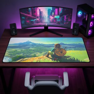 May include: A rectangular desk mat featuring a vibrant, colorful illustration of a character sitting on a cliff overlooking a vast landscape with a mountain in the distance. The mat has a black border and rests on a dark wooden desk surface.