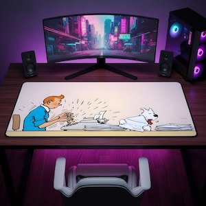 May include: A rectangular desk mat featuring a printed illustration of a person with orange hair in a blue shirt typing on a typewriter, with a white dog holding an envelope nearby. The mat has a light cream background and a black border edge.