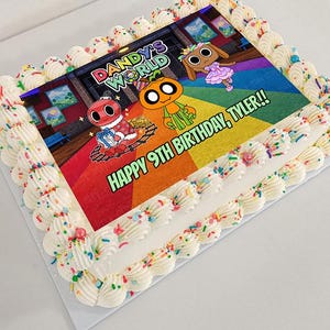 Könnte beinhalten: Ein rechteckiger Blechkuchen mit weißem Zuckergussrand und bunten Streuseln. In der Mitte befindet sich ein essbares Bild der Dandy's World-Figuren mit dem Text DANDY'S WORLD und HAPPY 9TH BIRTHDAY, TYLER!! in einem lebendigen Design.