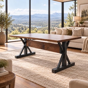 Può includere: Un tavolo da pranzo rettangolare con un piano in legno marrone liscio e una trave di supporto orizzontale. Il tavolo presenta due basi in metallo nero a cavalletto con un design a forma di X, che offrono una base solida al piano.
