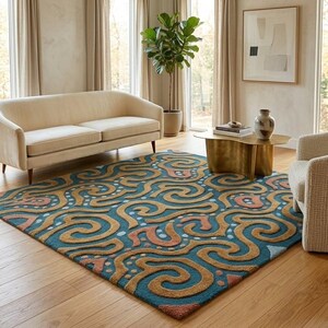 May include: A rectangular area rug featuring a deep teal background with a raised, textured pattern of swirling golden-brown lines, interspersed with small light blue dots and muted coral-colored organic shapes across the entire surface.
