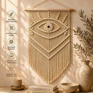 May include: A beige macrame wall hanging featuring an evil eye design, suspended from a wooden dowel. The text reads: MYSTIC EVIL EYE, MACRAME WALL HANGING PATTERN, Knotted with intention. Made by you. BabyPurl Co. MODERN MACRAME COLLECTION, HANDMADE BEAUTY, TIMELINESS ENERGY.