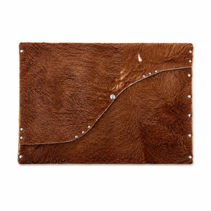 May include: A rectangular clutch bag crafted from brown cowhide with a textured fur finish. The front flap features a curved edge secured by a single central metal snap button, with small silver-toned metal studs lining the curved seam and edges.