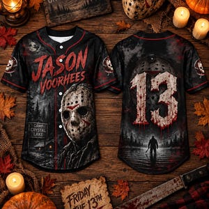 May include: A black baseball jersey featuring a graphic of a hockey mask, the text JASON VOORHEES, and a Camp Crystal Lake sign on the front. The back displays the number 13 in a blood-splattered font above a silhouette of a figure in a lake.